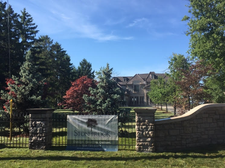 Scenic shot of Stonebrook landscaping sign on fence of large residential property in Russel Woods.