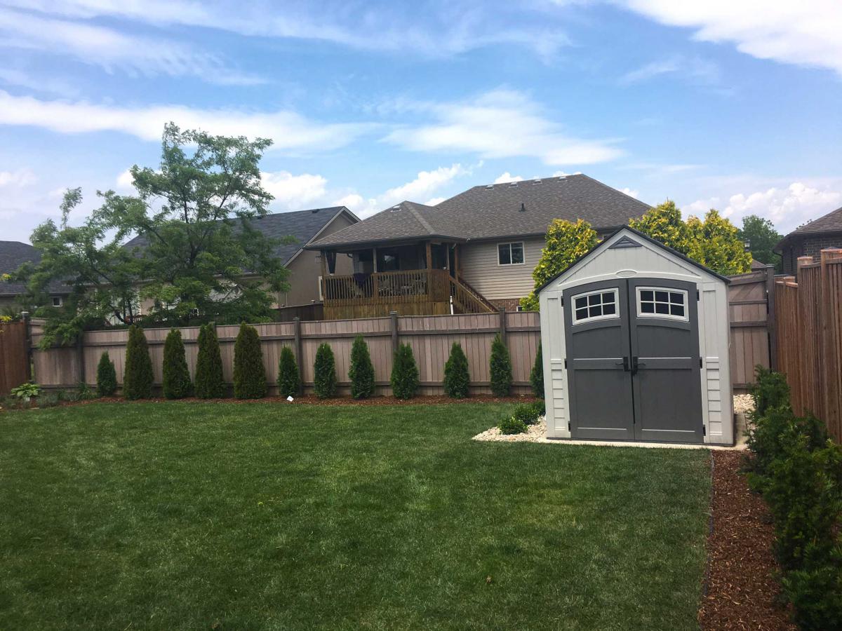 Wide photo of shrub work in a residential backyard.